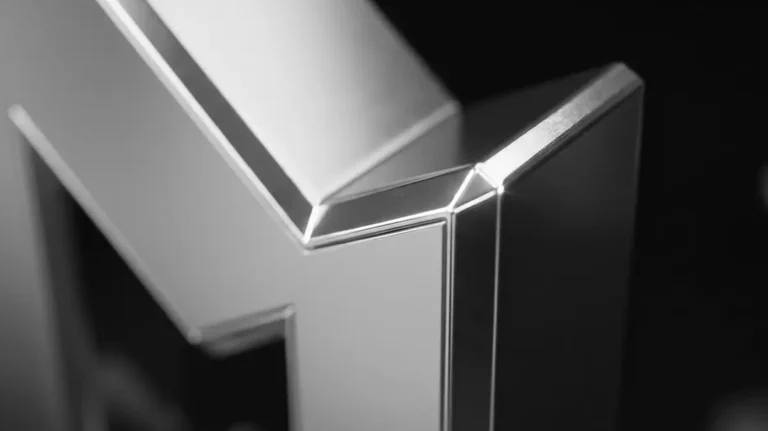 Close-up of the Nuxeno 3D logo in brushed metal